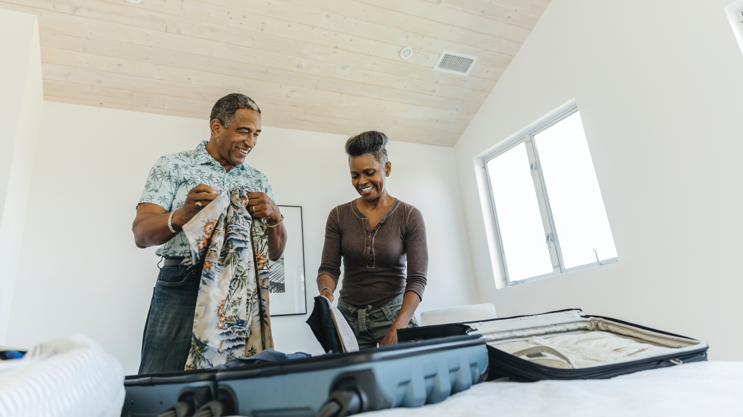 couple packing suitcase in bedroom