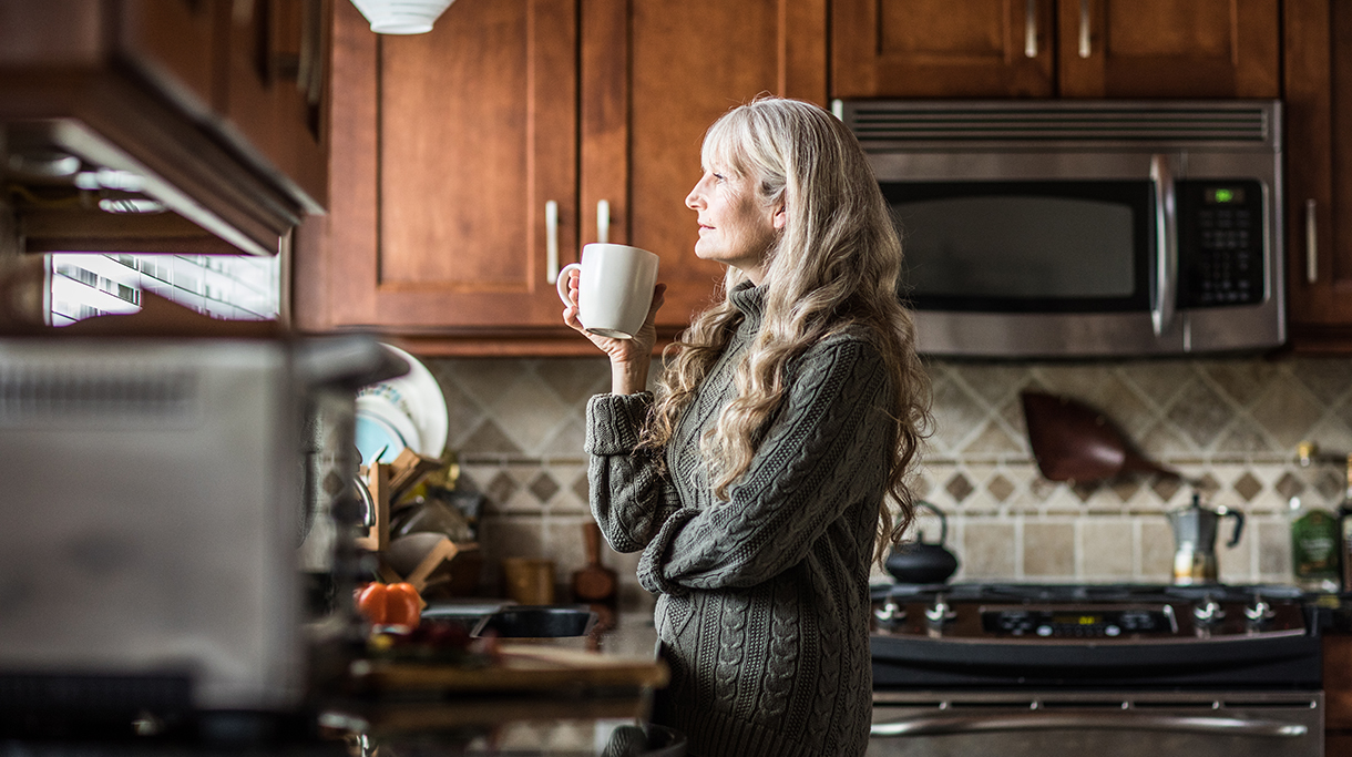 Woman drinking coffee in kitchen