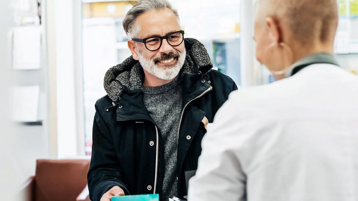 Man speaking to pharmacist