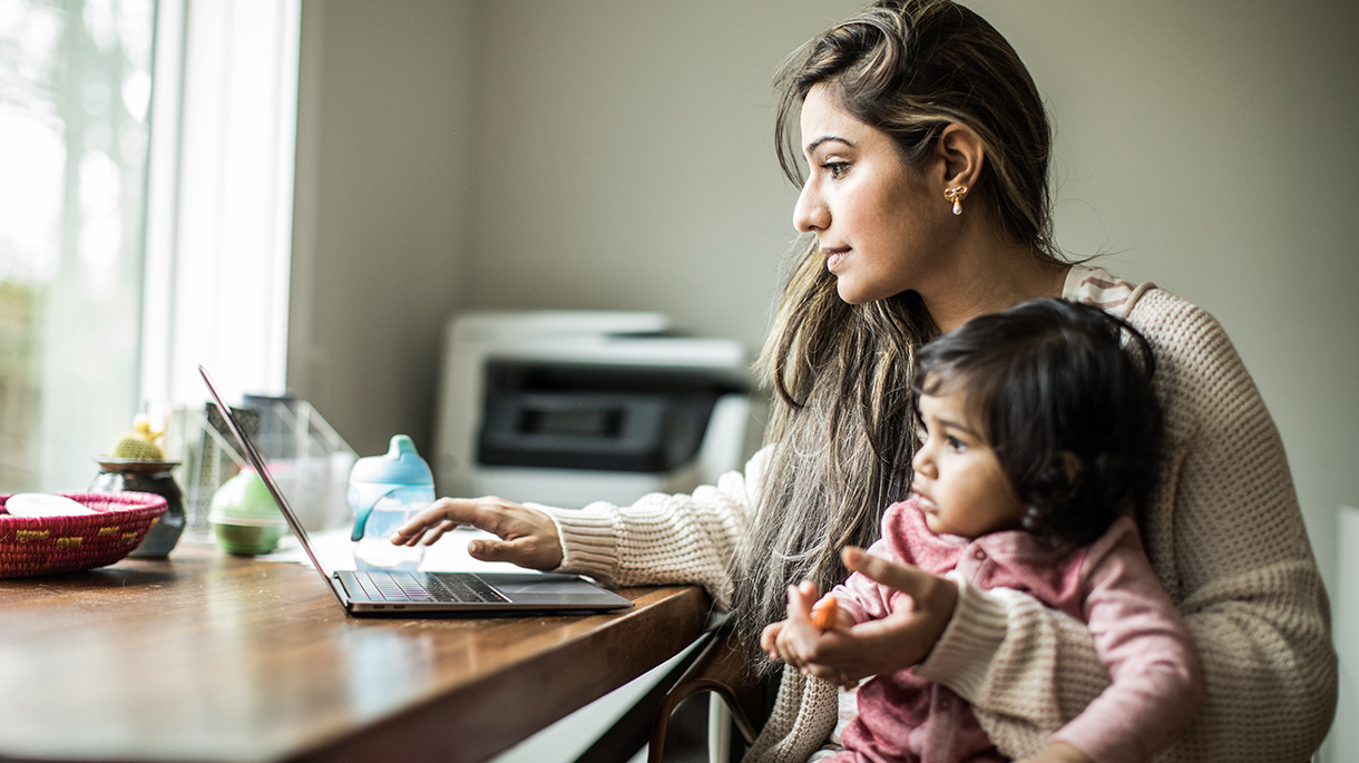 Woman using laptop with child