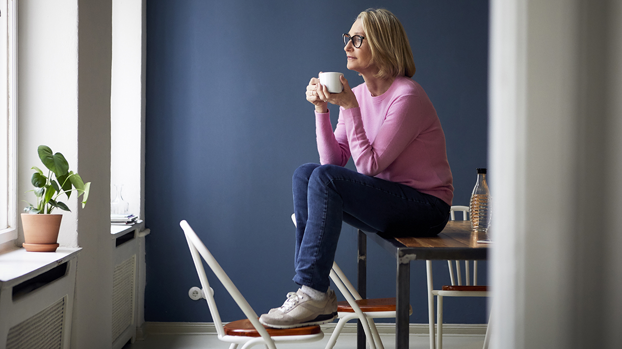 Woman drinking coffee by a window