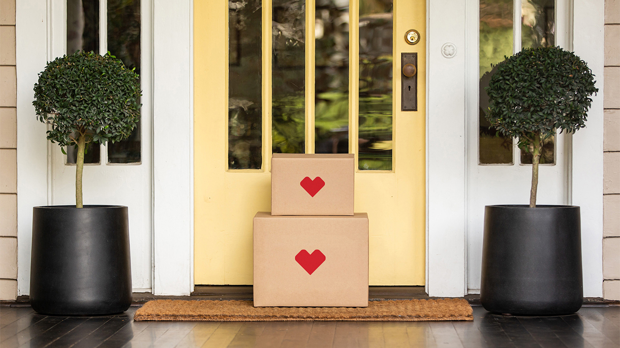 Two stacked shipping boxes at front door of a home